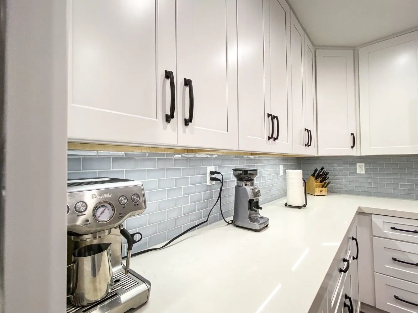 Breville espresso machine and coffee station on white quartz counters